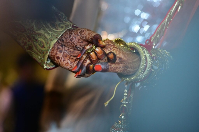 A beautiful capture of mehndi-decorated hands symbolizing love and tradition in a wedding ceremony.